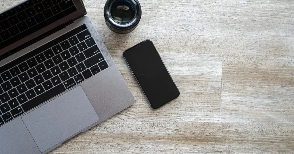 Arnaque aux sentiments : un ordinateur et un smartphone posés sur un bureau