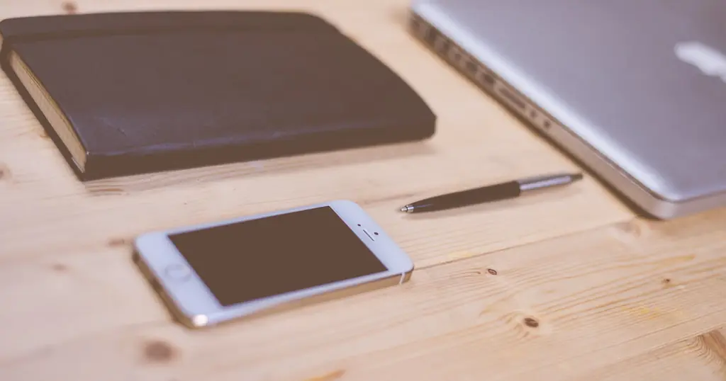 Écrire un premier message : un smartphone posé sur un bureau en bois