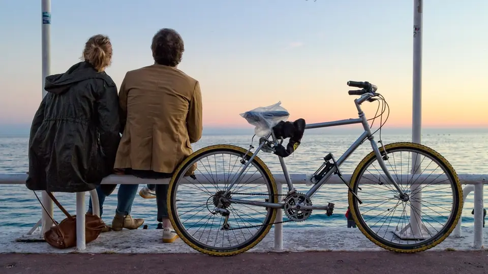Premier rendez-vous après un site de rencontre : un couple assis face à la mer, deux vélos à côté