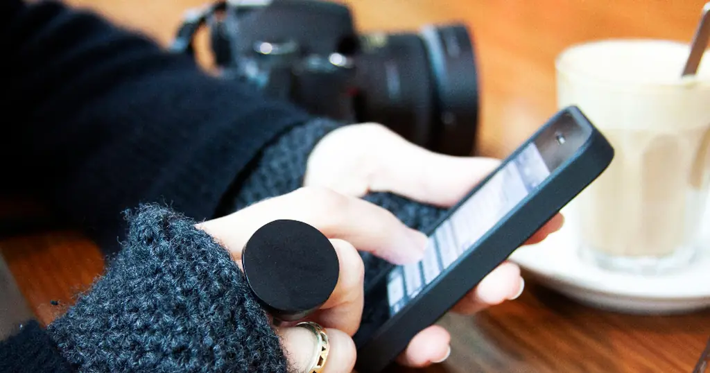 Application de rencontre ouverte sur un smartphone, à côté d’un café
